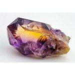 Closeup view of a polished ametrine gemstone showcasing a striking mix of purple and yellow hues within the quartz crystal. the bicolor gemstone appears highly transparent, making it ideal for use in fine jewelry design and gemstone collections.