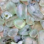 Prehnite jewel heap up on light varnished wood texture